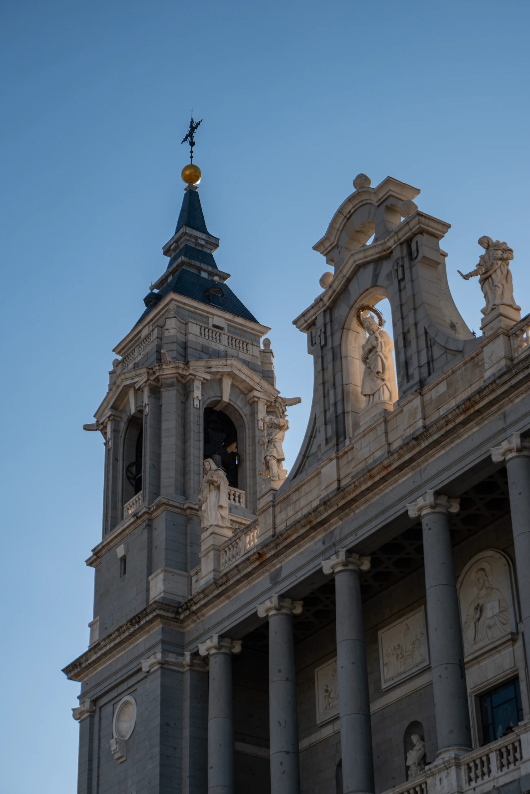Stone cathedral facade and bell tower against a blue sky