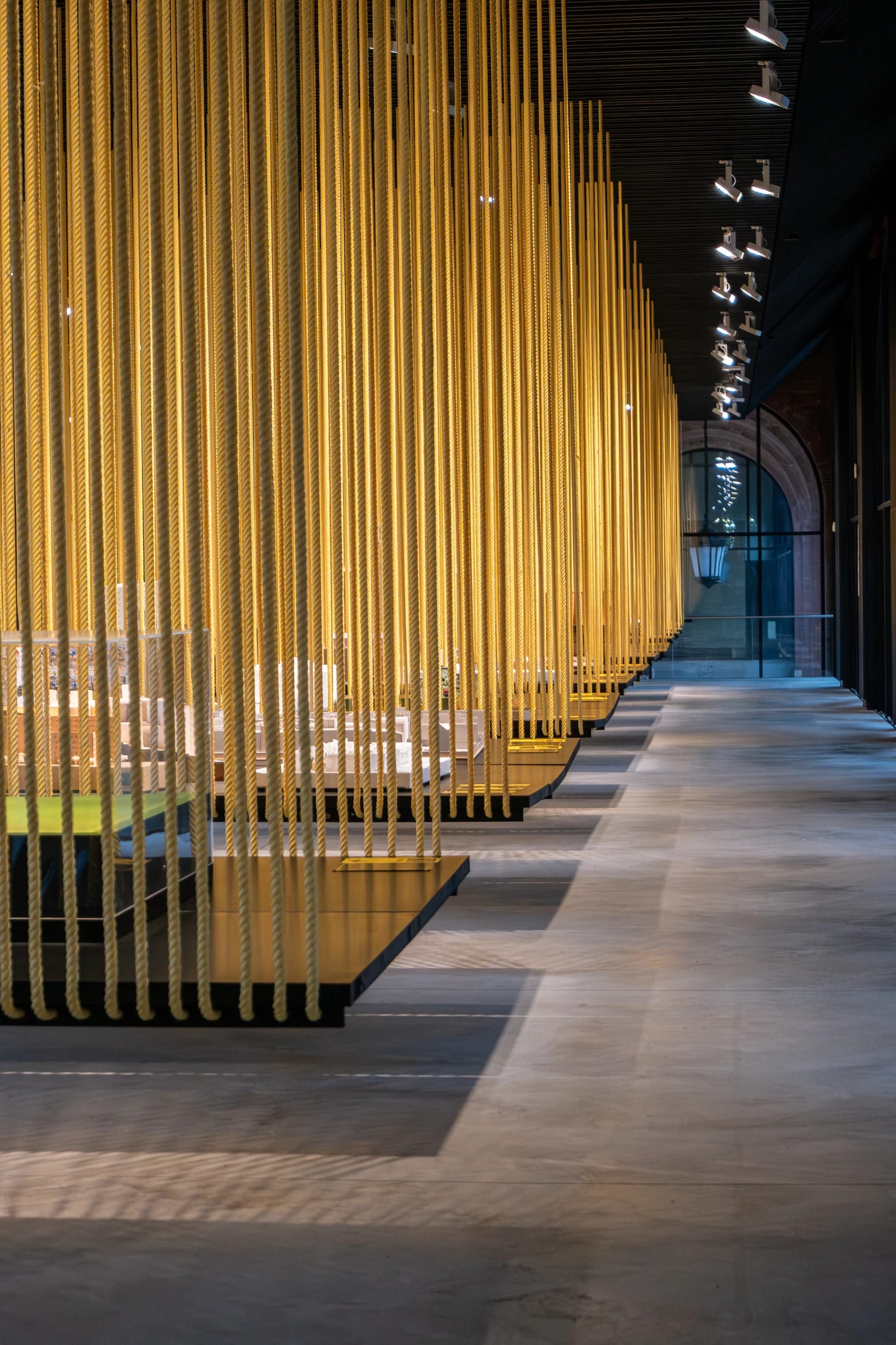 Rows of yellow hanging ropes and seats in a gallery