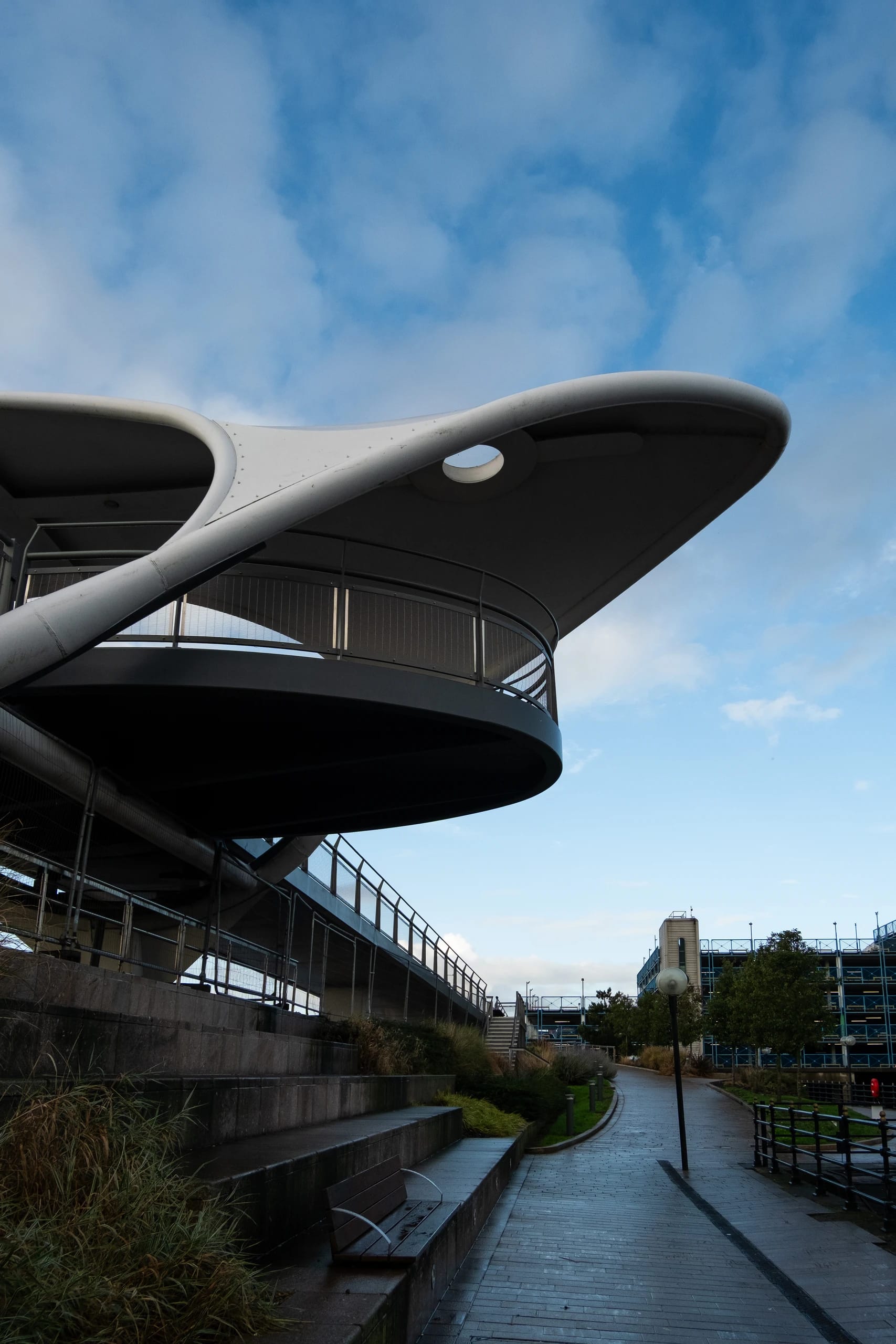 The curved canopy and circular walkway of a pedestrian bridge